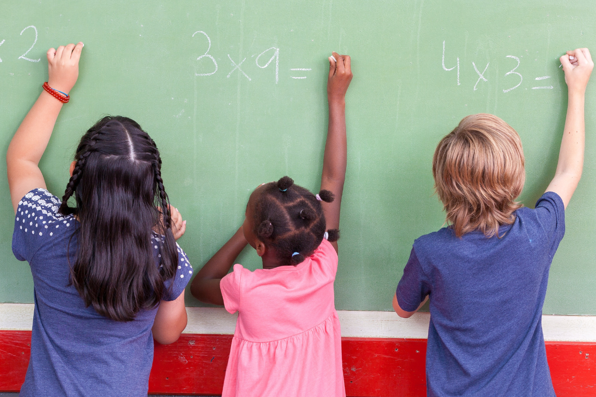 Niños escribiendo números en una pizarra