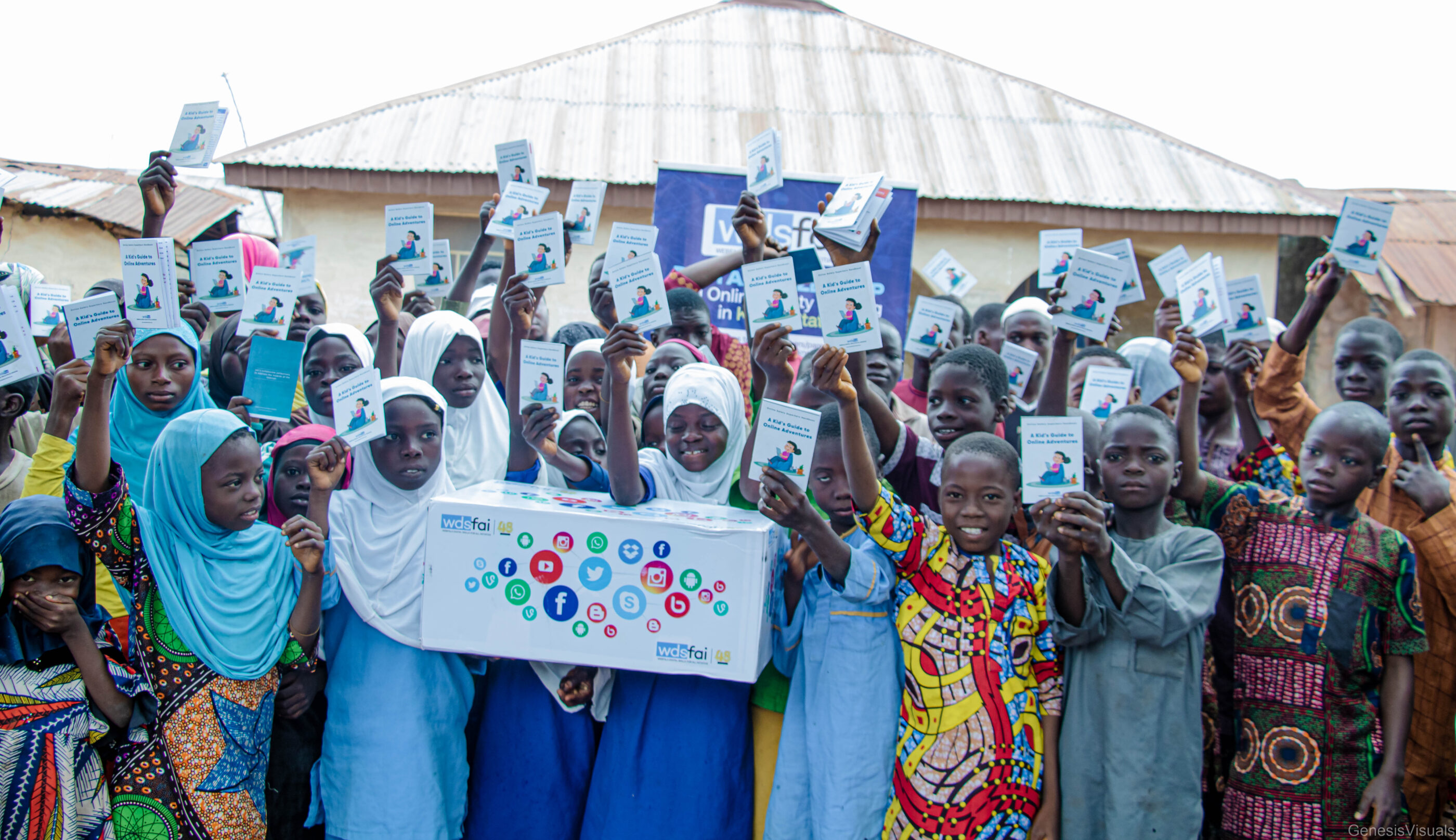 A diverse group of children in hijabs proudly holds tcards after completing a digital safeguarding course.